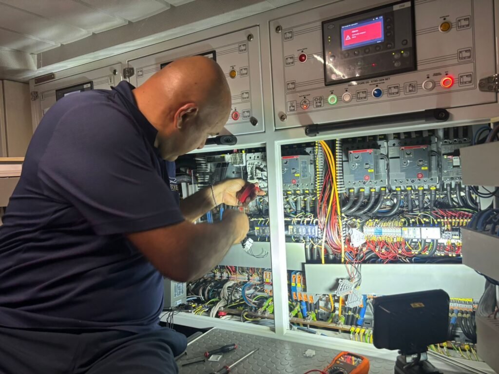 Boatique technician working on a yacht electrical switchboard