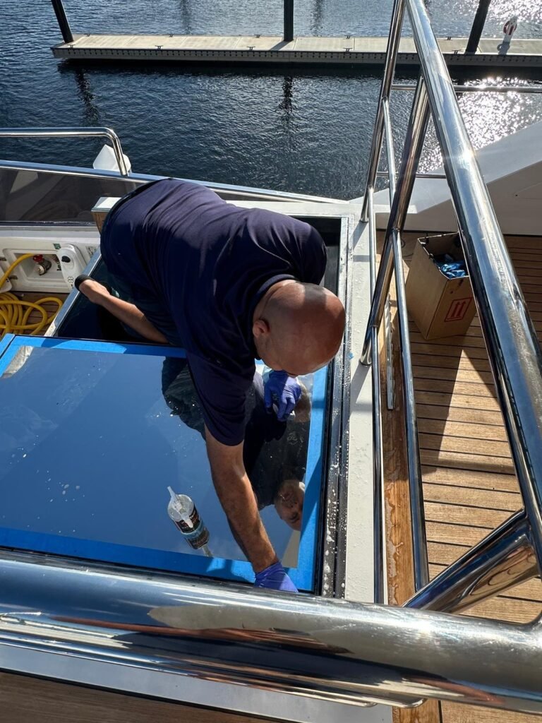 Boatique technician servicing an Allufer Tempesta glass hatch on a yacht